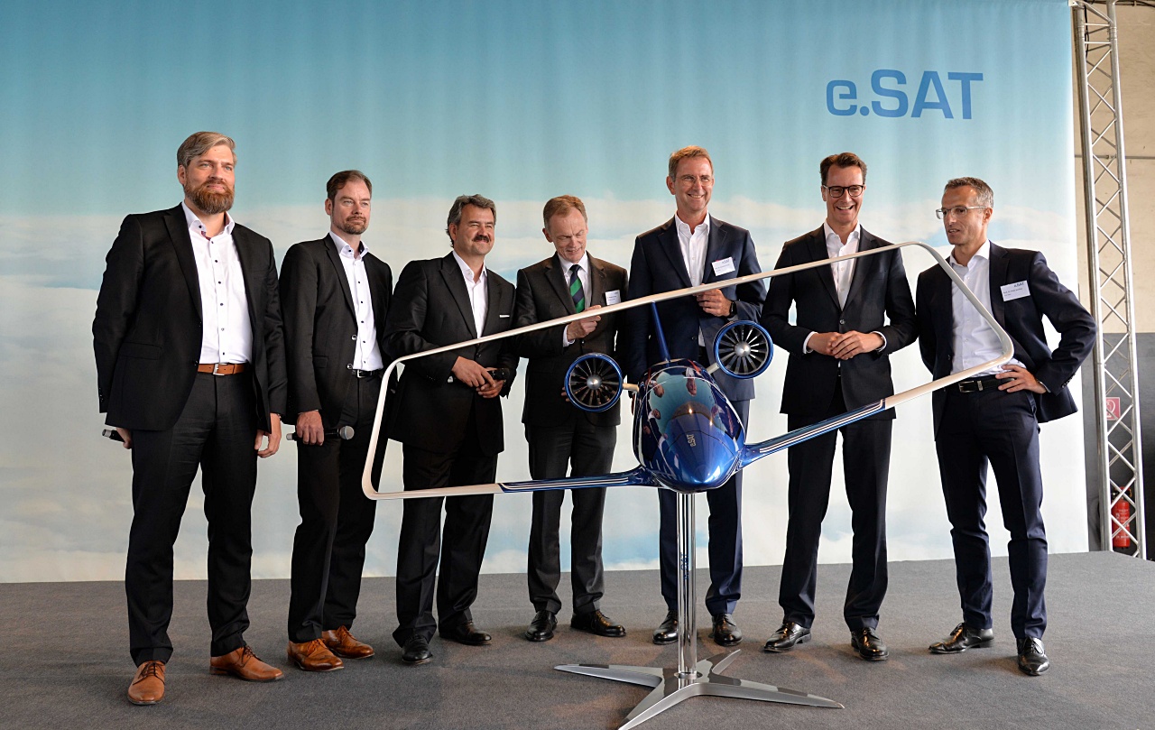 © e.SAT GmbH | Caption: Unveiling of the Silent Air Taxi model: left to right: Prof. Dr. Kai-Uwe Schrö-der (e.SAT GmbH), Prof. Dr. Eike Stumpf (e.SAT GmbH), Prof. Dr. Frank Janser (e.SAT GmbH), Dr. Hendrik Schulte (State secretary, Ministry of Transport of the Federal State of North Rhine-Westphalia), Prof. Dr. Günther Schuh (e.SAT GmbH), Hendrik Wüst (Minister of Transport of the Federal State of North Rhine-Westphalia) and Prof. Dr. Peter Jeschke (e.SAT GmbH)